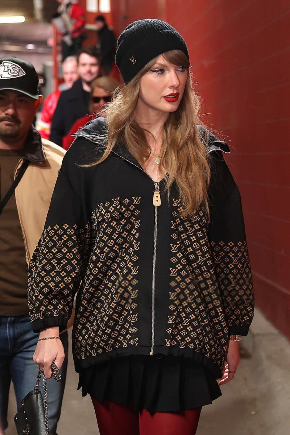 Taylor at a Chiefs game wearing a large black zip up hoodie