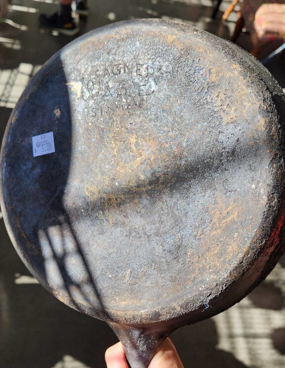 a crusty 10-inch cast iron skillet with "Wagner" vaguely visible in the inscription