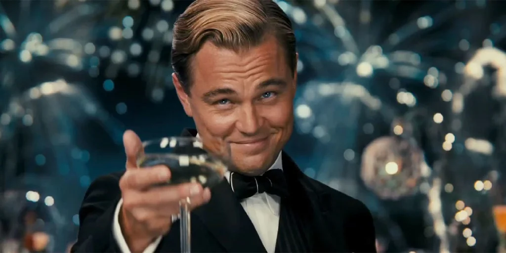 Leonardo DiCaprio from The Great Gatsby tipping his glass towards the viewer