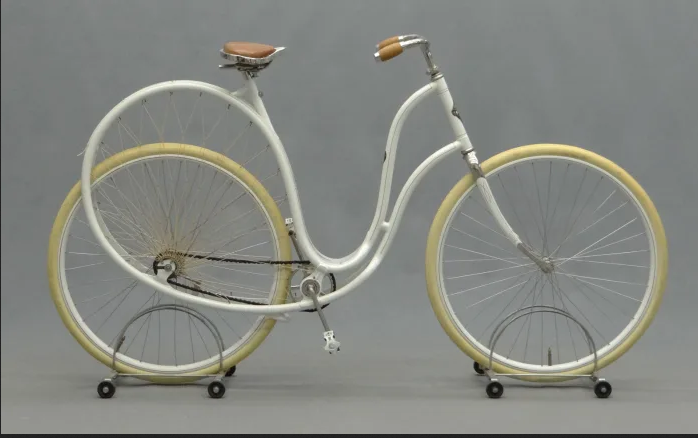 Pictured is a white low entry bicycle frame with white wheels which has an uncharacteristically swooped rearstay that looks sort of like a fat ass