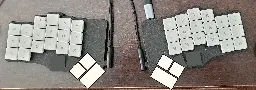 A Piantor Pro, mocked up with an angled thumb key cluster placing the keys under the thumbs. 42-key split keyboard, with agressive stagger; 3 thumb keys on each half in a 2x1, 45° rotated configuration.